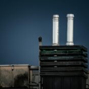Rooftop with chimneys against a dark sky, showcasing industrial architecture.