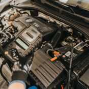Close-up view of a mechanic diagnosing a Volkswagen engine with specialized equipment.