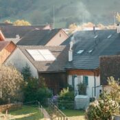 Picturesque rural village scene with cottages and smoky chimneys in springtime.