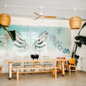 Bright dining space with modern decor, tropical plants, and abstract artwork.