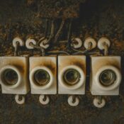Close-up of vintage ceramic electrical switches, showcasing industrial decay and retro design.