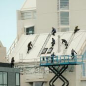 Construction workers repairing a modern roof in Reykjavík, highlighting teamwork and safety.