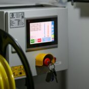 Close-up of an industrial control panel displaying safety features and a digital screen.