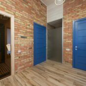 A stylish interior featuring blue doors, brick walls, and a sauna room in a cozy home setting.