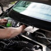 A mechanic working on car maintenance. Close-up of hands fixing vehicle engine.