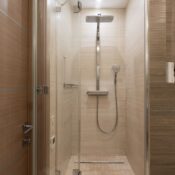 Sleek modern shower with glass door in a contemporary bathroom setting, featuring elegant interior design.