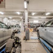 Interior of an automotive repair shop with cars undergoing maintenance and servicing.