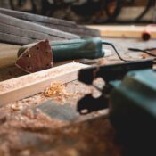 Close-up of various woodworking tools in a workshop, featuring wood shavings and equipment.