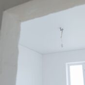 Bright white interior room with exposed electrical wiring and natural light.