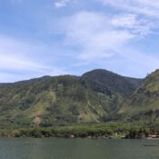 Beautiful landscape of Lake Laut Tawar surrounded by lush green hills in Takengon, Aceh, Indonesia.