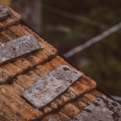 From above of metal element on shabby roof tiles of house in suburb