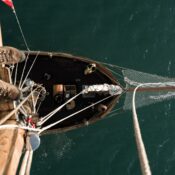 High-angle shot of a sailboat navigating through open waters. Perfect for travel and adventure themes.