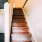 A classic wooden staircase leading to the upper floor in a brightly lit modern home.