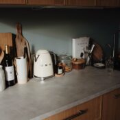 Composed utensils and appliance on gray stone counter of cozy kitchen in beam of soft sunlight