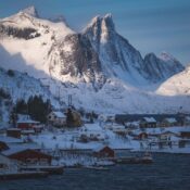 Picturesque winter scene of snow-covered mountains and fishing village in Lofoten.