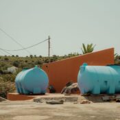 Bright blue tanks and rustic architecture in Las Hayas, Canarias, Spain under summer light.