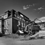 Monochrome image of a construction site featuring a modern brick building under development.
