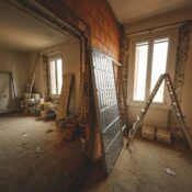 Interior view of a room under renovation with construction materials and a ladder.