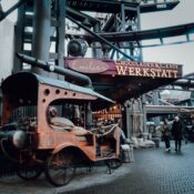 Rustic vintage vehicle outside a candy workshop in an industrial setting.