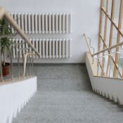 A sleek indoor stairway with modern railings and large windows, offering a minimalist design.