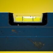 Detailed view of a spirit level with a vibrant yellow backdrop.