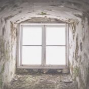 An eerie window framed in a derelict building in Hiiu County, showcasing time's impact.