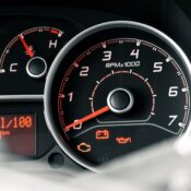Detailed view of a car dashboard featuring tachometer, odometer, and various indicators.