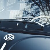 Close-up of a classic dark blue Volkswagen Beetle with the VW emblem. Captures the essence of vintage automotive design.