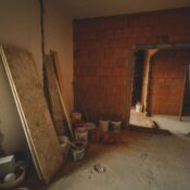 A red brick wall under construction with tools and materials scattered around in a renovation project.