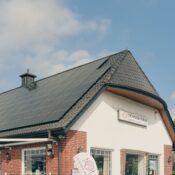 A red brick building with solar panels on the roof, under a clear blue sky, symbolizing sustainability and renewable energy.