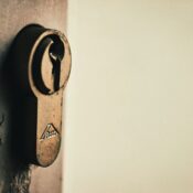 Close-up of vintage keyhole on a weathered wooden door, capturing rustic charm.
